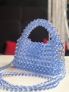 A soft blue beaded bag is an elegant accessory that attracts the eye with its delicate shade of blue and the shine of the beads. It is made from high quality materials, creating a sophisticated and sophisticated look. This bag is perfect for special occasions when you want to add a touch of luxury and femininity to your look. Elegant Light Blue Top Handle Bag, Blue Rectangular Bag With Pearl Handle, Elegant Blue Bag With Pearl Handle, Blue Handmade Evening Bag For Everyday Use, Blue Beaded Shoulder Bag As Fashion Accessory, Light Blue Rectangular Evening Bag, Blue Tote Shoulder Bag For Party, Light Blue Evening Bag With Detachable Handle, Elegant Handmade Blue Shoulder Bag