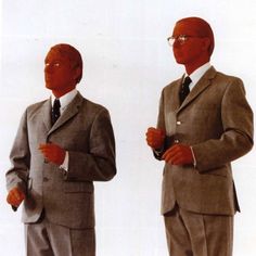 two mannequins dressed in suits and ties standing next to each other with their hands together