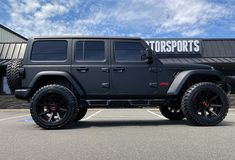 a black jeep is parked in front of a store with the words motorsportssports on it