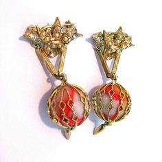 These caged marble pins are done in a gold tone setting. The marbles dangle from a small fan shaped pin set with simulated pearls and clear rhinestones. A small dart shaped dangles from beneath each marble. Each pin measures approximately 1 3/4", excluding the little drop at the bottom. These pins are in excellent condition and are quite RARE. The priceis for the pair.  What aunique addition this pair will be to add to any collection. Never seen any like this before. Small Fan, College Station, Clear Rhinestones, Pin Badges, Dart, Brooch Pin, Brooches, Gold Tones, Marble