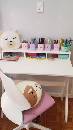 a white desk topped with a stuffed animal and lots of pencils on top of it