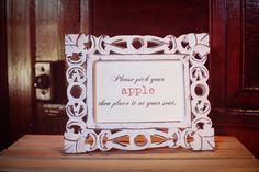 an apple sign sitting on top of a wooden table