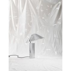 a lamp that is sitting on top of a white sheeted surface with writing all over it