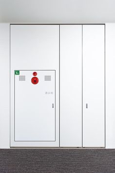 three white lockers with red buttons on them in an office building or conference room