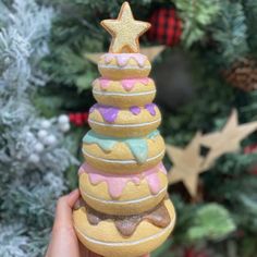 a hand holding up a decorated christmas tree ornament