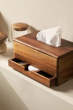 a wooden tissue dispenser sitting on top of a counter