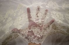 a woman's hand with white lace on it