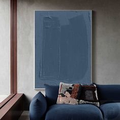 a blue couch in front of a painting on the wall