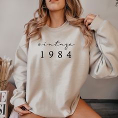 a woman wearing a sweatshirt with the words vintage printed on it