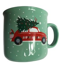 a red car with a christmas tree on the roof is parked in front of a green mug