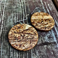 two wooden earrings are sitting on a table