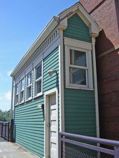 a blue house with a white door and window on the side of it's building