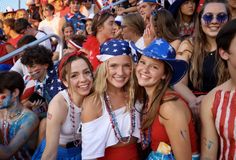 some girls are posing for the camera in front of an audience at a sporting event