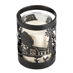 a glass candle holder with an image of a barn and trees on the inside, in front of a white background