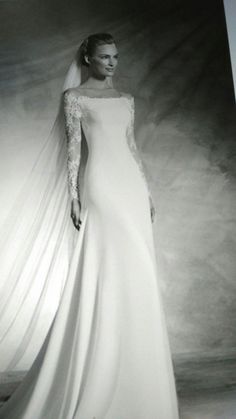 a black and white photo of a woman in a wedding dress with long veil on her head