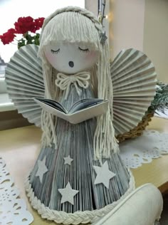 a paper doll reading a book on top of a table