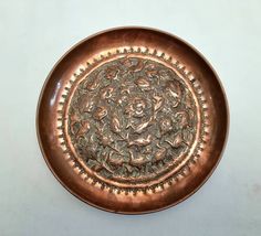 a decorative metal plate on a white table