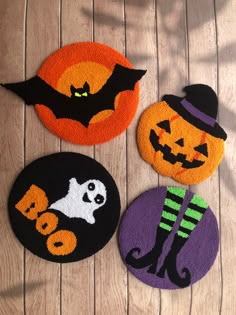 three halloween door mats on a wooden floor with pumpkins, bats and ghostes