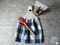 a blue and white checkered dress next to a red spatula on a stone floor