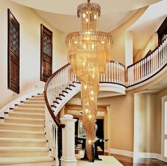 a large chandelier hanging from the ceiling in front of a staircase with stairs