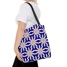 Introducing our DipaliZ Brand White Floral AOP Tote Bag – available in sizes S, M, and L! Get ready to make a statement with our eye-catching white floral pattern on an electric blue background. This tote bag is the perfect accessory for a day at the beach or a fun outing in town.Made from 100% Polyester, this tote bag is not only stylish but durable too, ensuring it lasts for seasons to come. The boxed corners and black cotton handles add a touch of elegance, while the black lining brings sophi Floral Tote Bag, Fashion Statements, Blue Background, Blue Backgrounds, Blue Floral, Electric Blue, Black Cotton, Floral Pattern, Turning