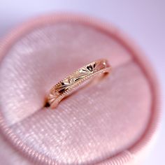 a close up of a ring on a pink velvet case