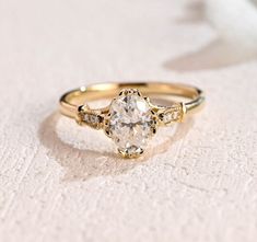 a close up of a gold ring with a diamond in the center on a white surface