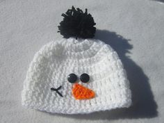 a crocheted snowman hat with a black pom - pom