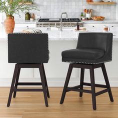 two black bar stools sitting in front of a kitchen counter