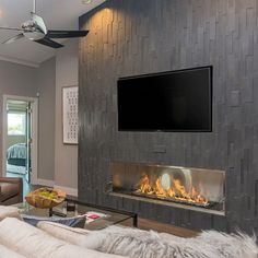 a living room with a flat screen tv mounted on the wall and a fire place