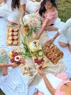 a group of people sitting around a table with food on it