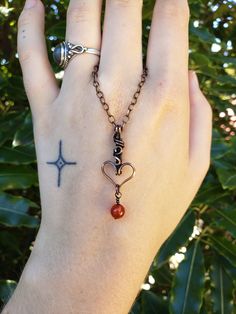 Heart pendant hand-wrapped with pure copper wire accented with a Carnelian bead. This pendant is oxidized and polished for an antiqued look, and coated with a tarnish resistant lacquer, meaning it will not brown further and will retain its shine. The tarnish resistant coating also protects from greenish coloration of the skin that comes with bare copper wire. Pendant comes with a complimentary 45cm copper plated chain which is removable and interchangeable. Check out my Instagram to see more of my work: @violet.designsnz Copper Heart Pendant For Jewelry Making, Unique Copper Necklace With Heart Pendant, Unique Copper Heart Pendant Necklaces, Unique Copper Heart Pendant Necklace, Handmade Copper Heart Pendant Necklace, Handmade Copper Heart Necklaces, Hand Wrapped Carnelian Pendant Jewelry, Handmade Copper Heart Pendant Jewelry, Bohemian Heart-shaped Copper Jewelry