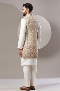 Beige Nehru jacket with intricate thread embroidery in geometric and floral pattern.
Component: 1
Pattern: Embroidered
Type Of Work: Geometric
Neckline: Open
Sleeve Type: Sleeveless
Fabric: Georgette
Color: Beige
Other Details: 
Note: Kurta and pant worn by the model is not for sale
Occasion: Wedding - Aza Fashions Embroidered Beige Nehru Jacket For Transitional Season, Fitted Outerwear With Chikankari Embroidery For Transitional Season, Fitted Chikankari Embroidery Outerwear For Transitional Season, Winter Nehru Jacket With Multicolor Chikankari Embroidery, Festive Designer Beige Nehru Jacket, Winter Multicolor Embroidered Chikankari Nehru Jacket, Traditional Nehru Jacket With Intricate Embroidery, Festive Embroidered Sleeveless Outerwear, Fitted Sleeveless Outerwear With Floral Embroidery