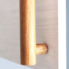 a wooden door handle on a white wall