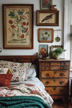 a bed sitting in a bedroom next to a dresser with pictures on the wall above it