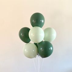 a bunch of green and white balloons in a vase