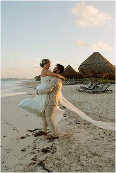 a bride and groom on the beach at sunset