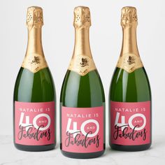 three bottles of sparkling wine are shown in this image, one is pink and the other is green