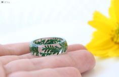 This living plant ring can be a wonderful gift for any occasion. They are made from high quality eco crystal resin and real dried green plants. To make this ring I use handmade silicone molds. I'm waiting for 2-3 days to let resin completely dry. After that I sanded and polished it using special techniques. I only use eco-friendly epoxy resin which is durable and long-lasting material. It will keep its original color if you keep it in dry place, away from direct sunlight. For finger sizes please Green Flower Ring Gift, Green Resin Flower Jewelry, Handmade Green Flower Ring, Handmade Green Flower Ring For Gift, Unique Green Flower Ring, Nature-inspired Green Jewelry With Birth Flower, Green Birth Flower Round Jewelry, Green Round Jewelry With Birth Flower, Green Birth Flower Jewelry