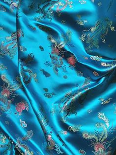 a blue silk fabric with gold and red flowers on the left side, and an intricately designed dragon design on the right side