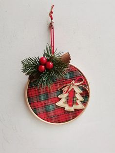 a christmas ornament hanging on a wall with a red and green plaid pattern