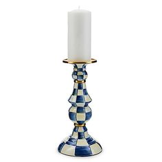 a blue and white checkered candle holder with a lit candle in the middle on a white background