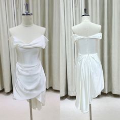 two white dresses on mannequins in front of curtains