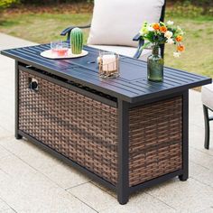 an outdoor table with flowers and drinks on it