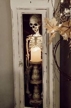 a skeleton in a cabinet with a candle