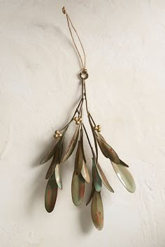 a bunch of metal leaves hanging from a wall