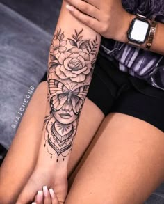 a woman's leg with a flower tattoo on her arm and the other hand