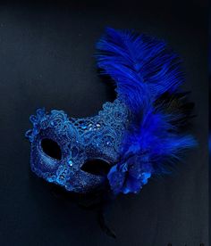 The brocade lace design with feathers adds a touch of sophistication and the jewels are carefully placed to catch the light and enhance your beauty. Securely and comfortably fits every face shape so you can enjoy a perfect evening at the masquerade ball.

Age Group/Gender - Adult/Women

Size/Type - One size fits all adults

Mask Color - Blue

Mask Material - Polyresin/Fabric

Accent Material - Gems Royal Blue Masquerade Mask, Elegant Eye Mask For Party, Elegant Carnival Party Masks, Elegant Masks For Mardi Gras Party, Elegant Evening Mask For Carnival, Elegant Evening Masks For Carnival, Elegant Blue Masquerade Mask For Parties, Elegant Headpieces For Mardi Gras Evening, Elegant Evening Headpieces For Mardi Gras