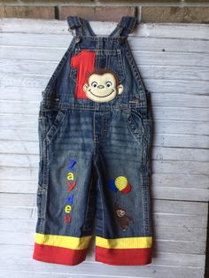 a pair of denim overalls with monkey applique on the front