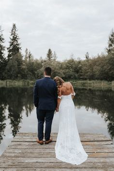 a bride and groom walking on a dock